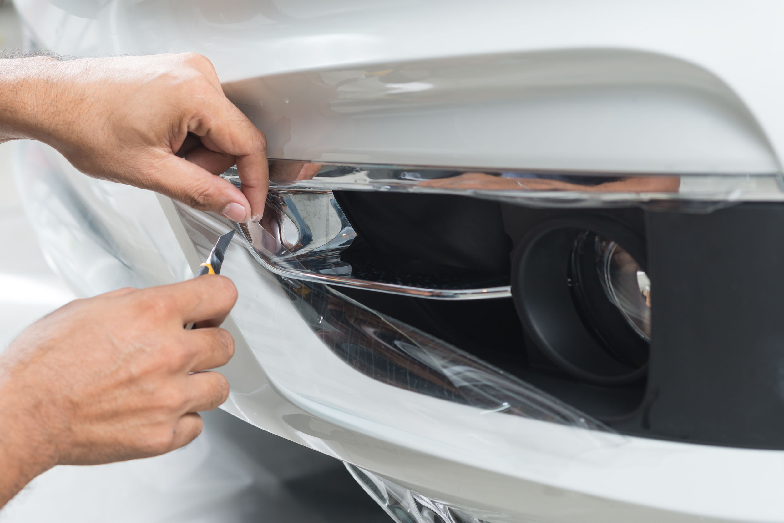 56485866 - paint protection film series : cutting paint protection film on white car